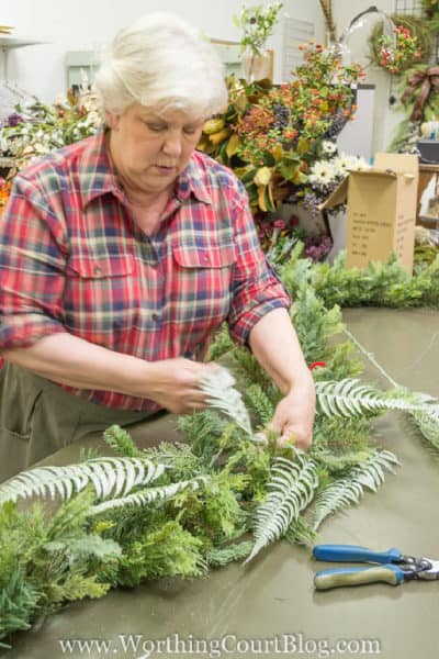 woman making a Christmas garland on a table