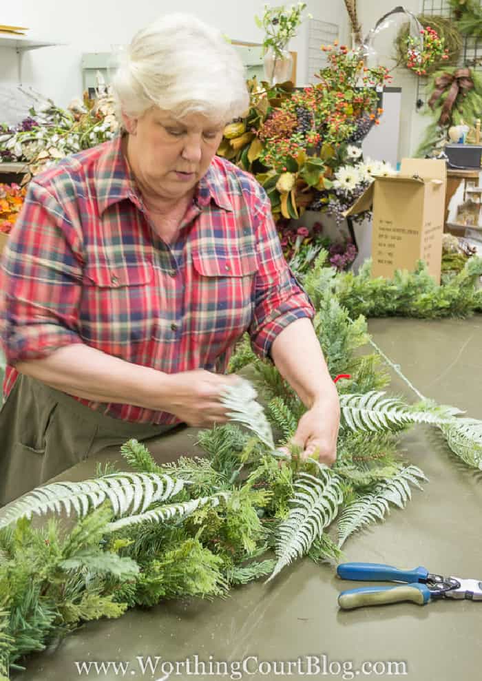 woman making a Christmas garland on a table