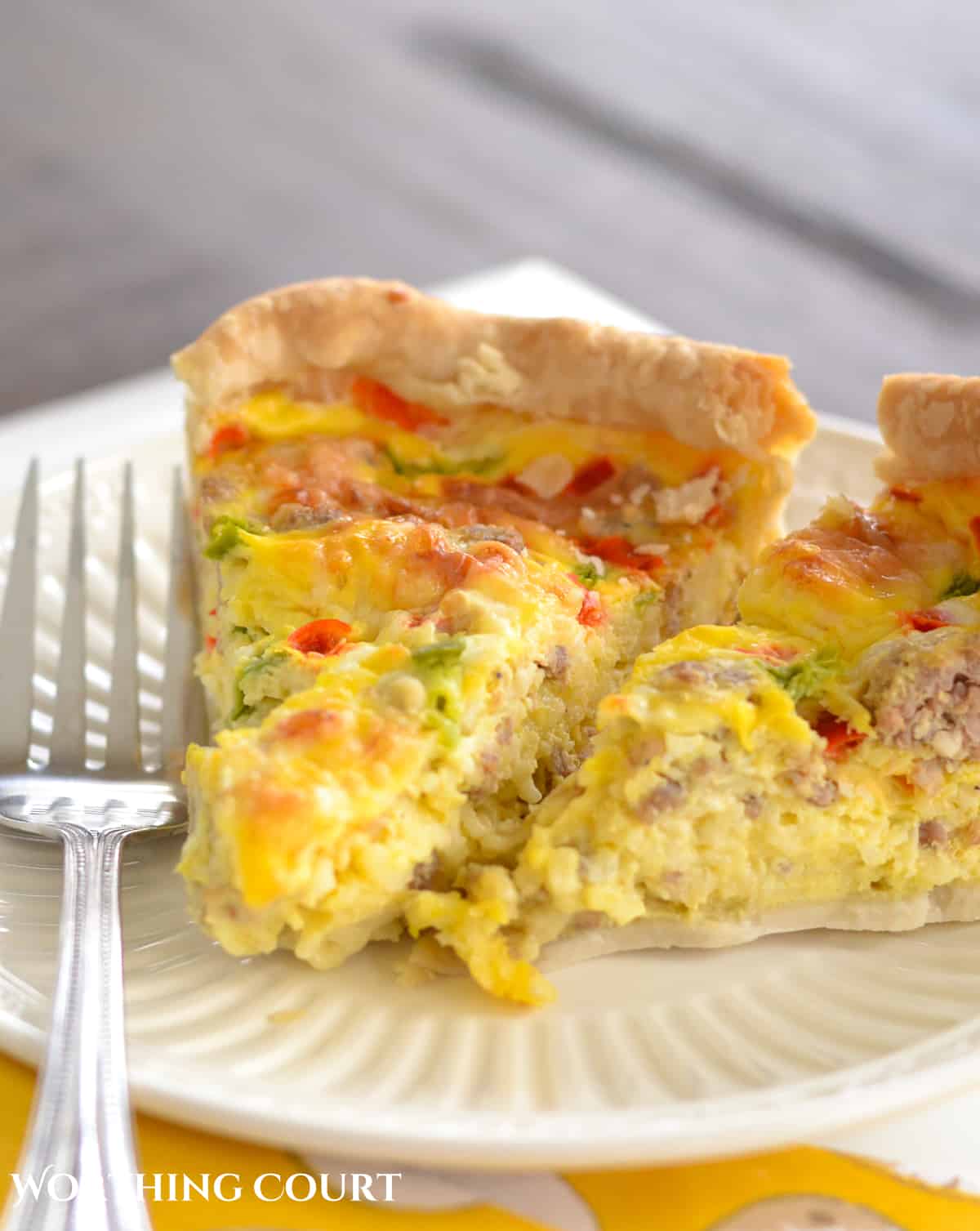 pieces of sausage and egg breakfast casserole on a white plate with a fork