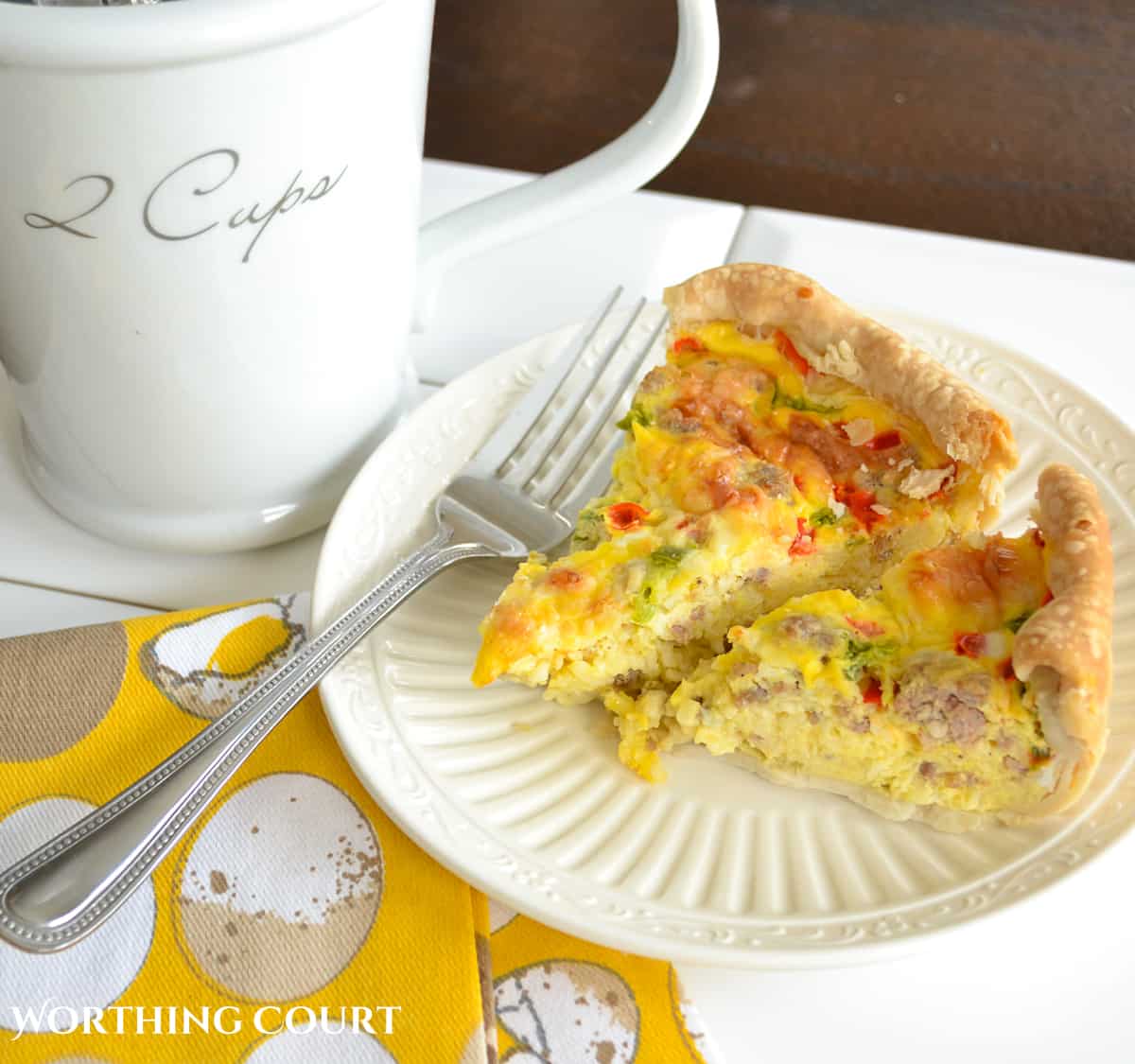 pieces of sausage and egg breakfast casserole on a white plate with a fork