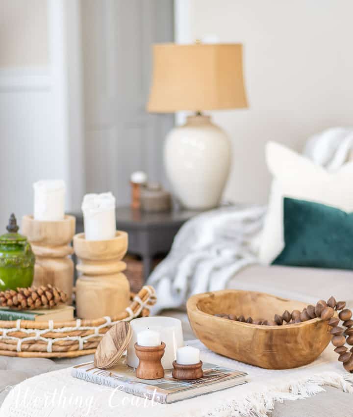 coffee table vignette with wood bowl, wood beads and wood candlesticks