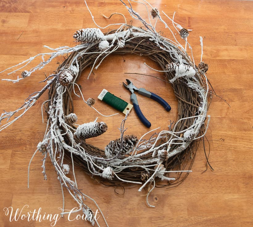 grapevine wreath, snowy garland, faux pine pieces and ribbon