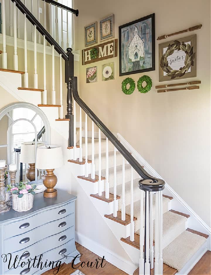 stairway with black handrail, white pickets and a gallery wall