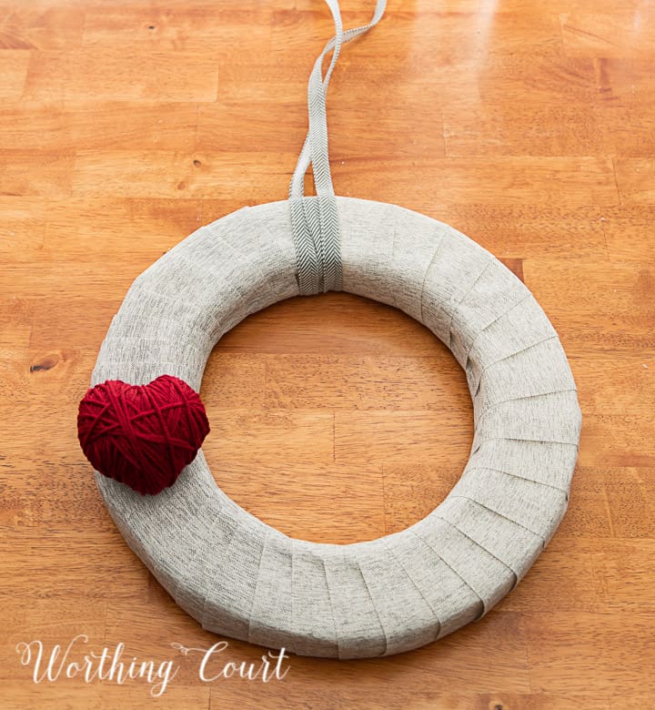 In process photo of tutorial about how to make a Valentine's Day wreath with yarn balls