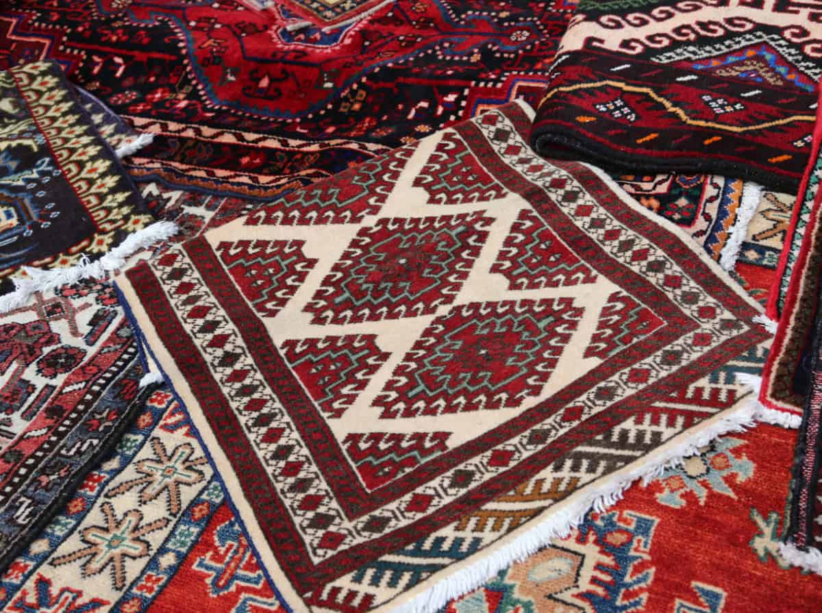 pile of similarly colored red rugs together