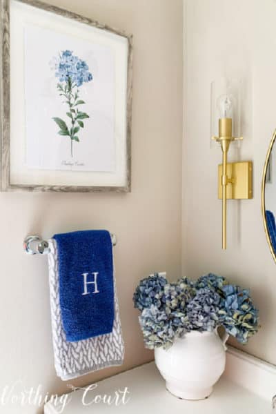 blue hydrangeas in a vase in a bathroom corner