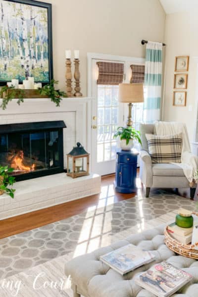 family room with white fireplace and gray recliner in corner with art and accessories