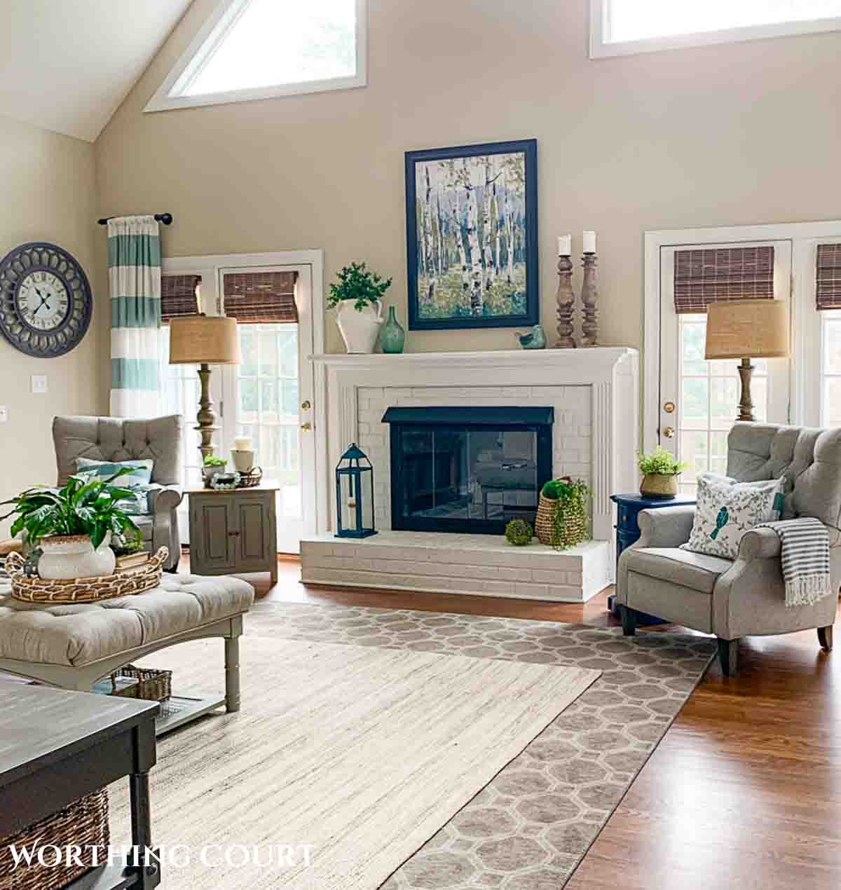 living room with white brick fireplace and neutral colored furniture and rugs
