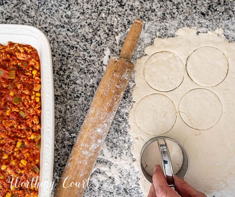 In process photo of making image of sloppy joe casserole topped with biscuits