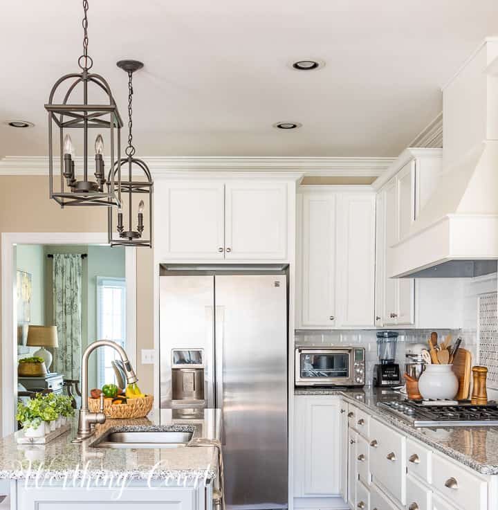 end view of kitchen with white cabinets and gray island