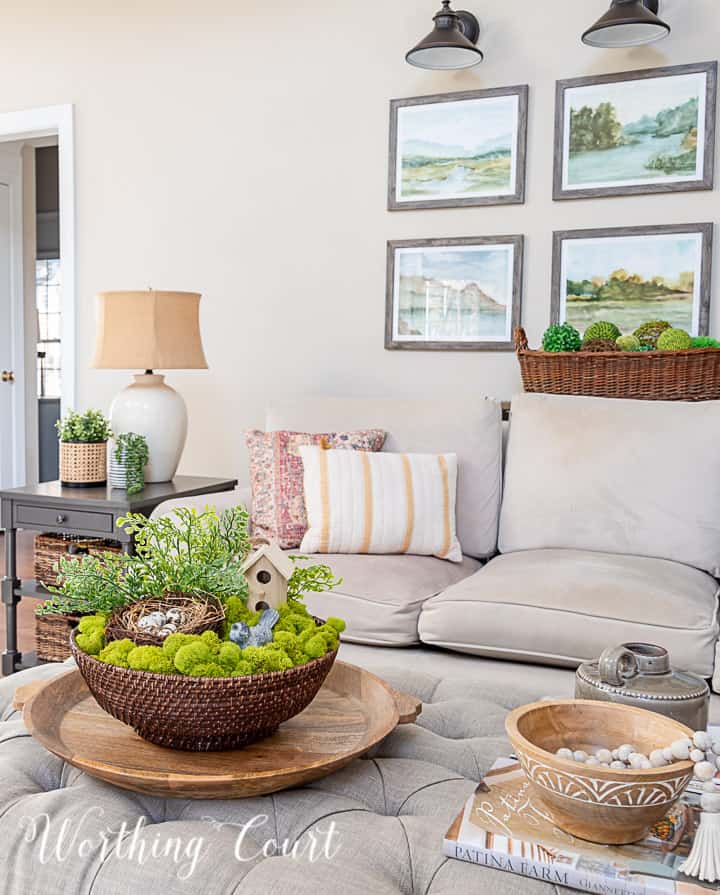 upholstered coffee table with spring decor and a gray couch with spring pillows in the background