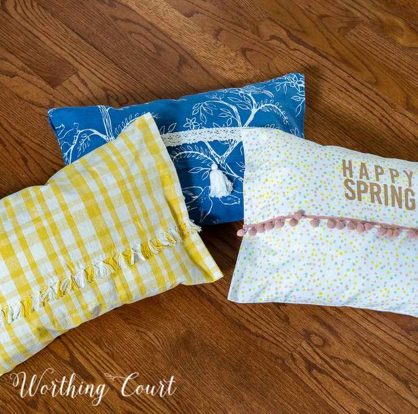 3 multicolored pillows lying in a group on a wood floor