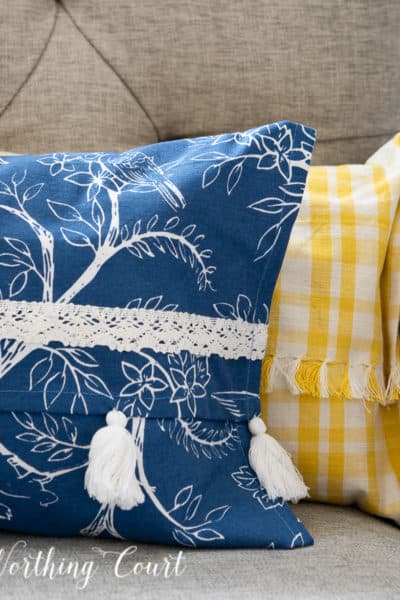 portion of a blue and white and yellow and white pillow in a gray chair