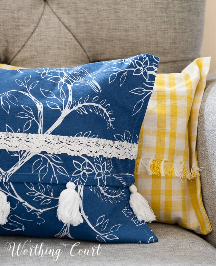 portion of a blue and white and yellow and white pillow in a gray chair