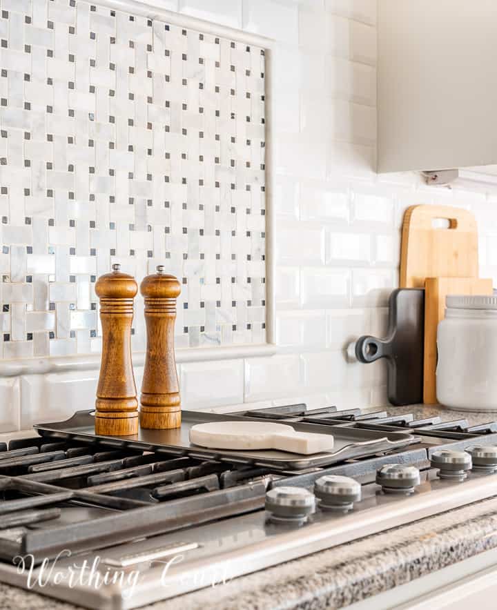 wood salt and pepper mill and marble spoon rest on top of burner griddle