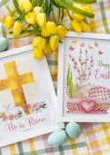 pair of framed Easter printables lying on a plaid piece of fabric