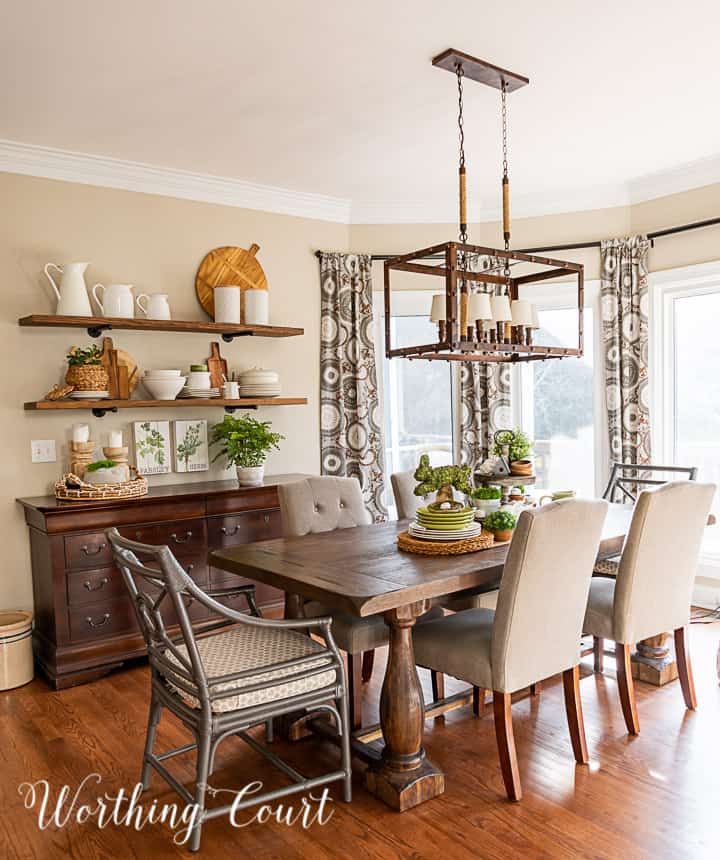 breakfast room with open wall shelves over a sideboard and spring decorations