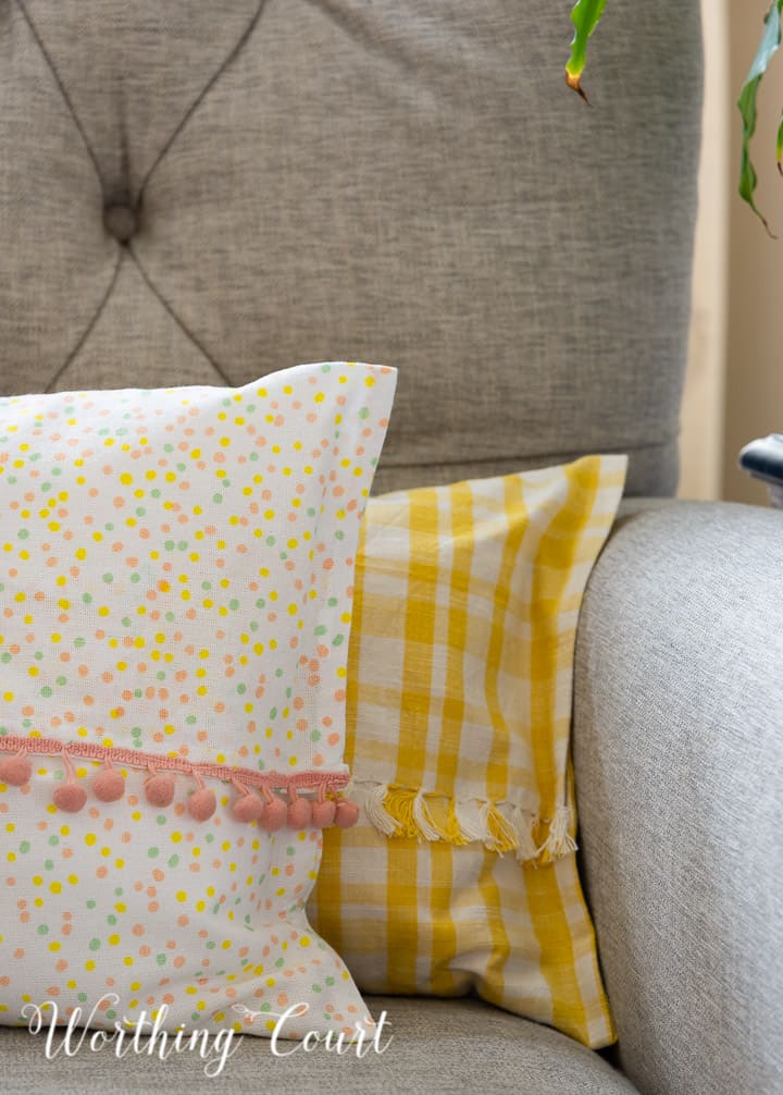 yellow and white and multi colored dots pillows in a gray chair