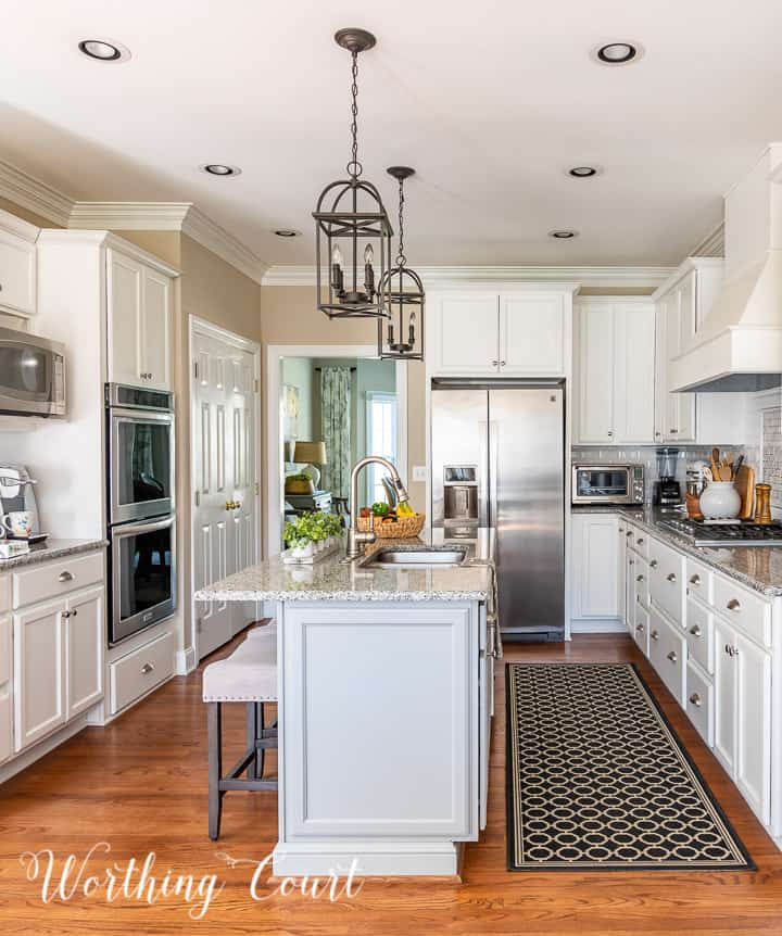 end view of kitchen with white cabinets and gray island