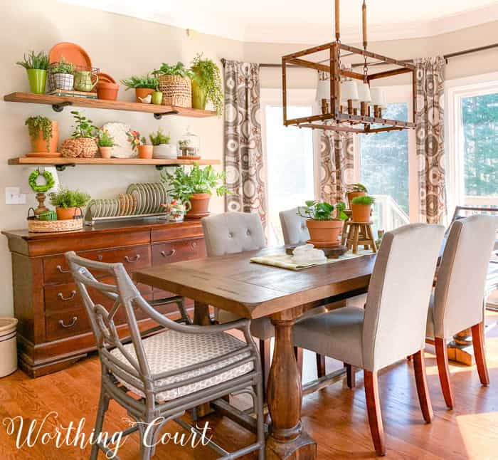 dining area with table, sideboard, open shelves and terra cotta decor