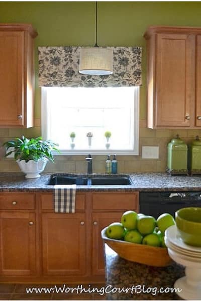 window and cabinets in a kitchen with green walls