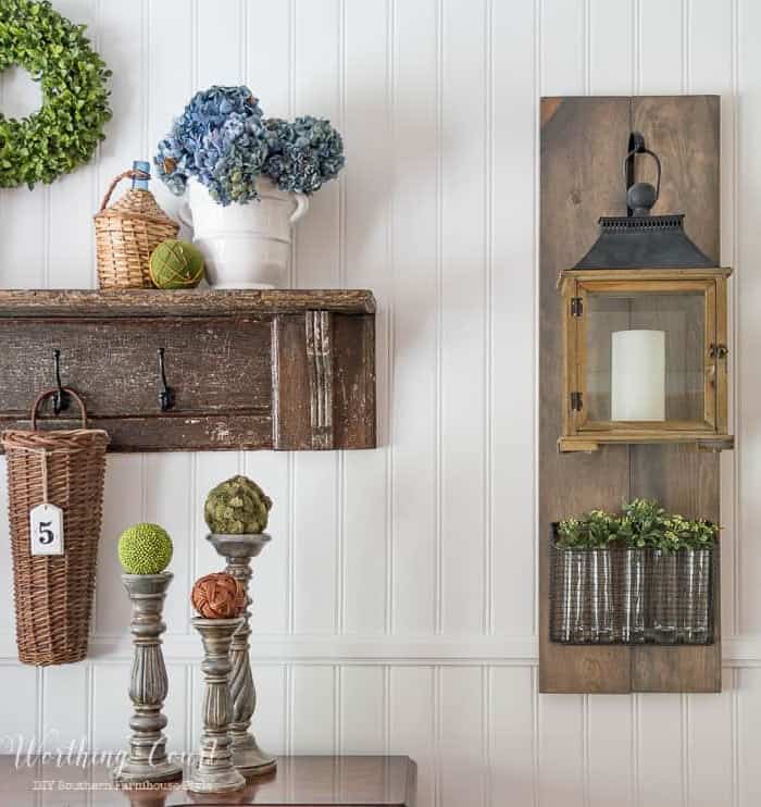 lantern and vintage shelf with farmhouse style accessories hanging on a white wall