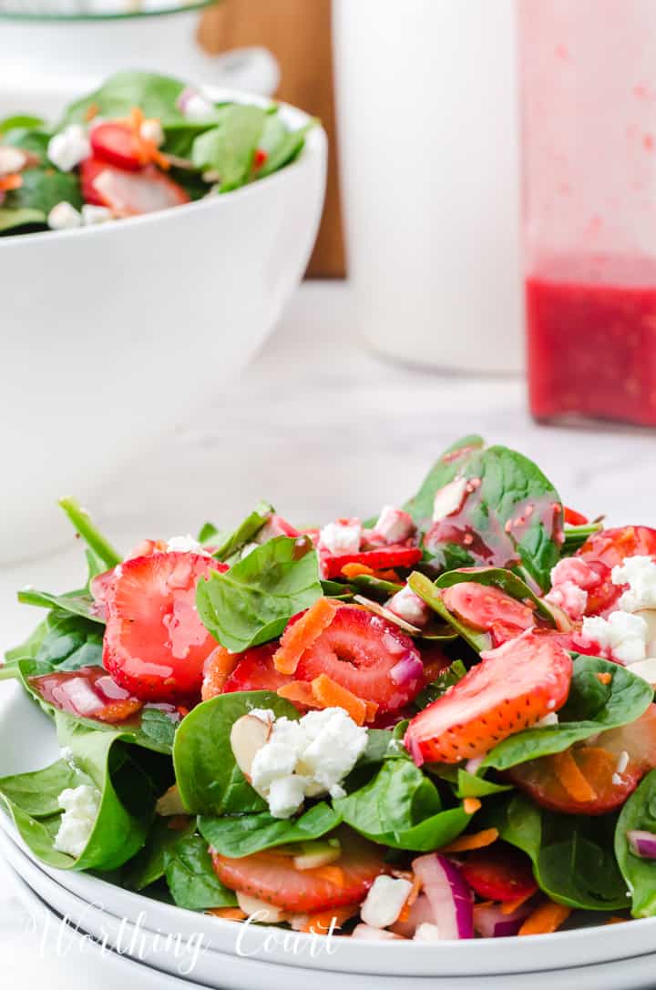 strawberry spinach salad in white bowls