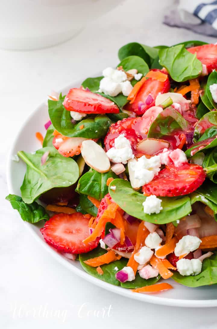 strawberry spinach salad in white bowls