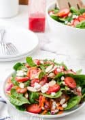 strawberry spinach salad in white bowls