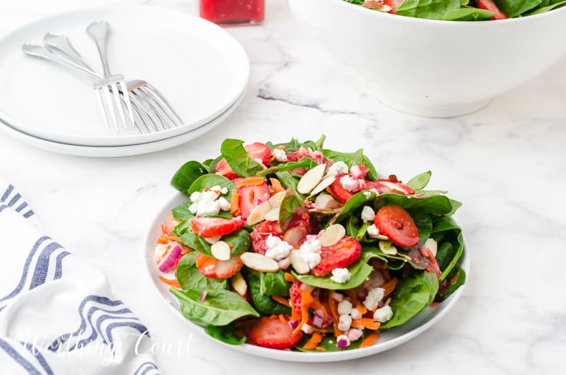 strawberry spinach salad in white bowls