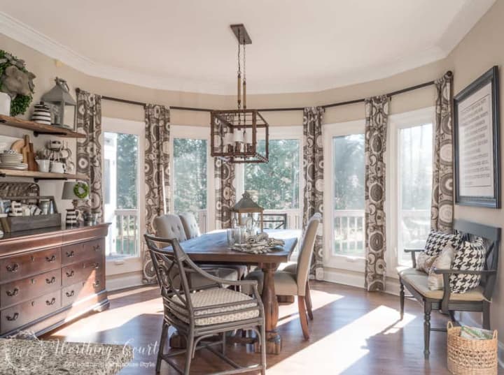 draperies and dining table in a large bay window