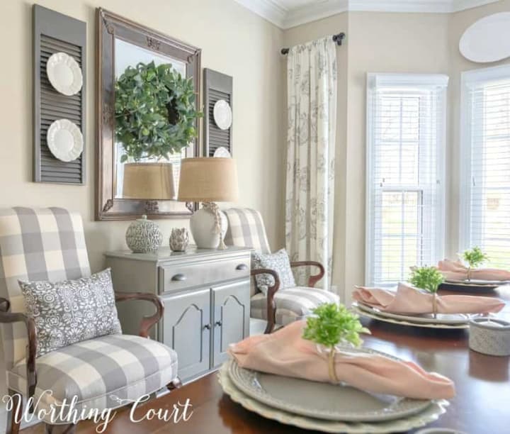 buffalo check chairs flanking gray chest with mirror above