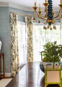 draperies in a traditional print fabric hanging in a bay window in a dining room