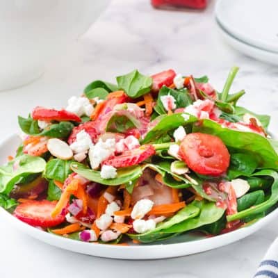 strawberry spinach salad in white bowls