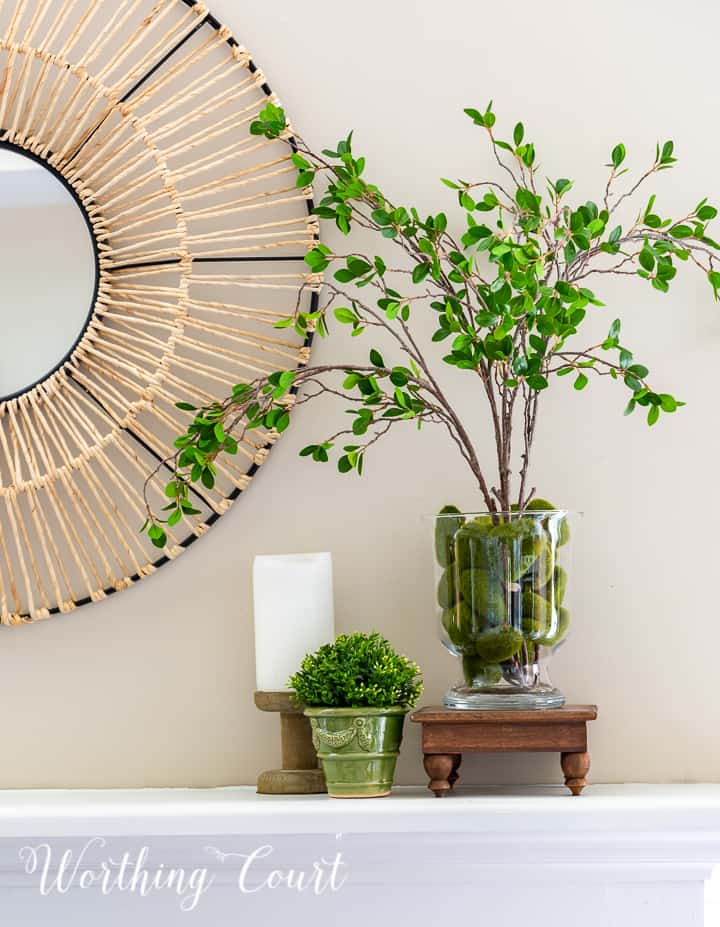 Summer mantel vignette with faux greenery and a candlestick