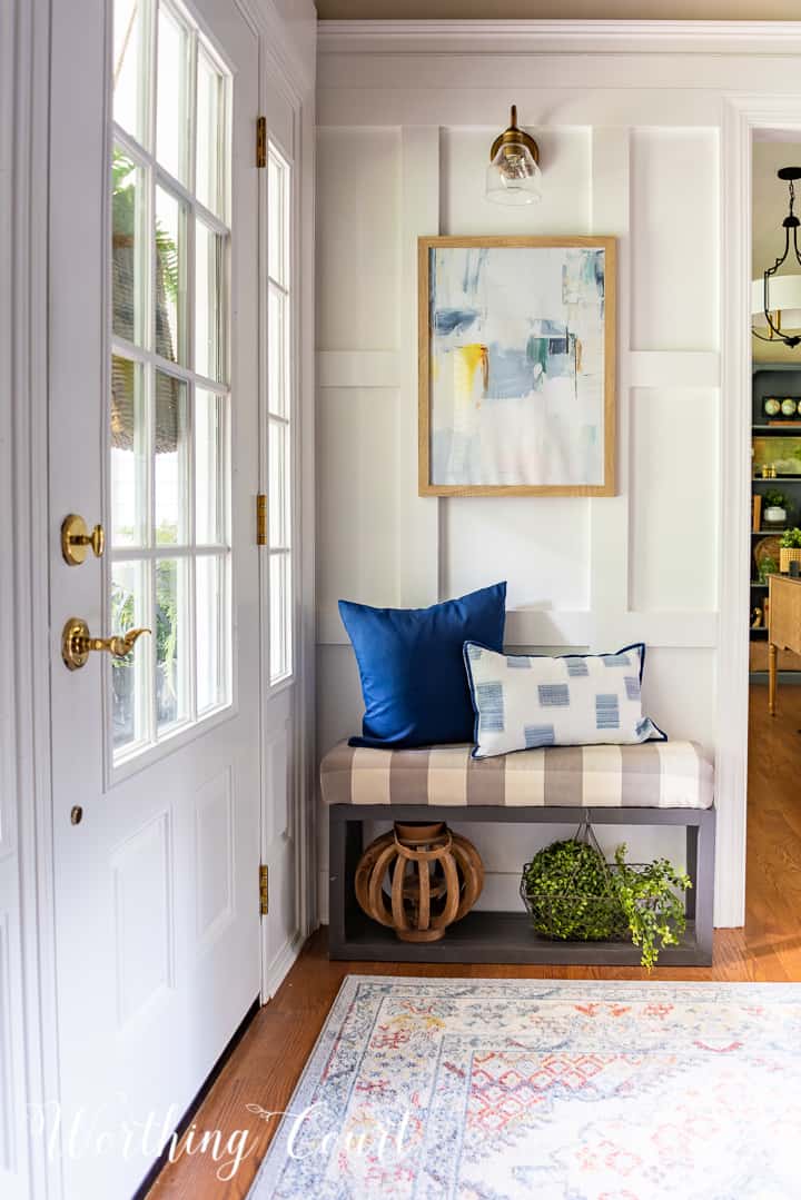 bench in front of white board and batten wall with artwork