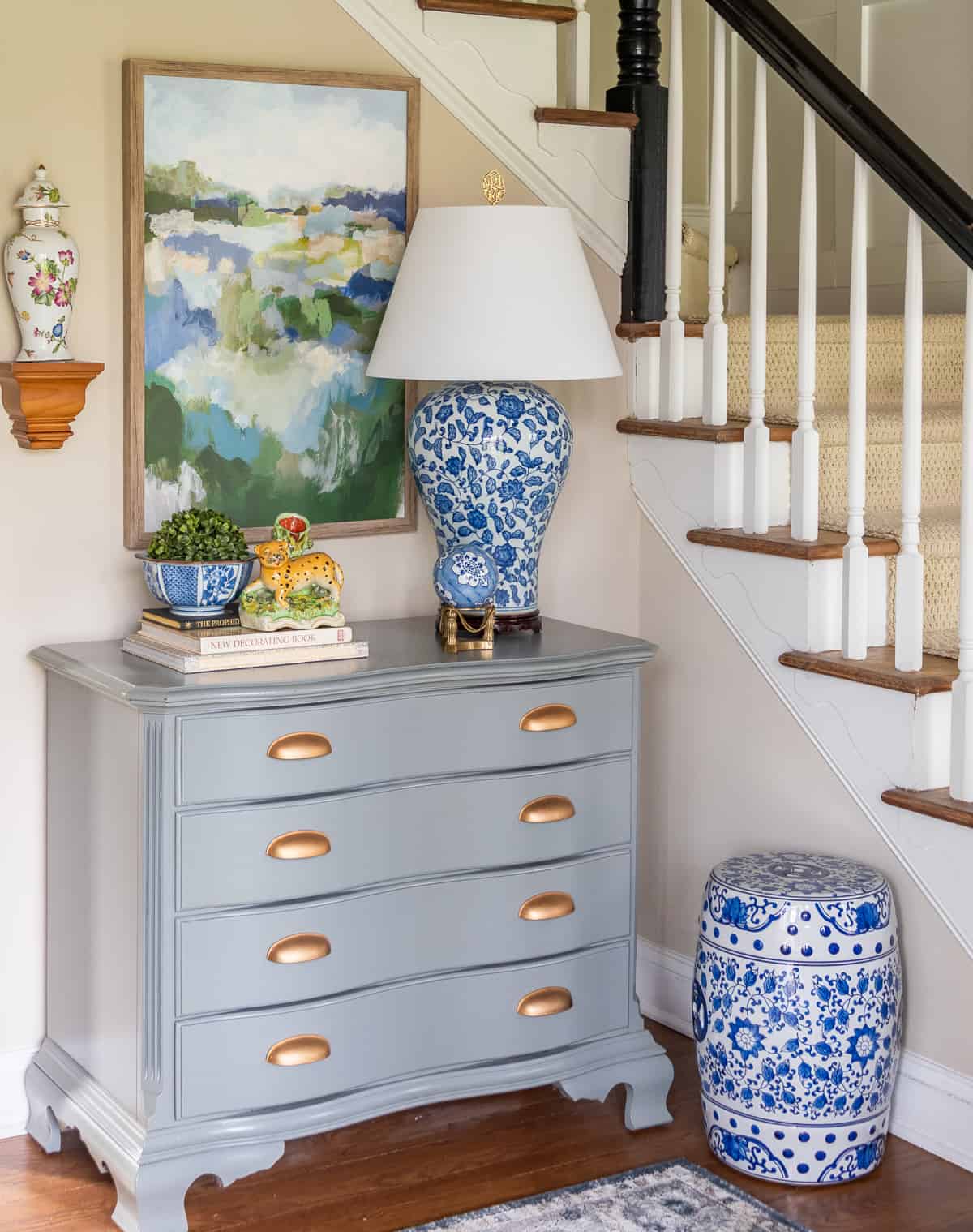 gray chest with blue and white spring decorations against beige walls