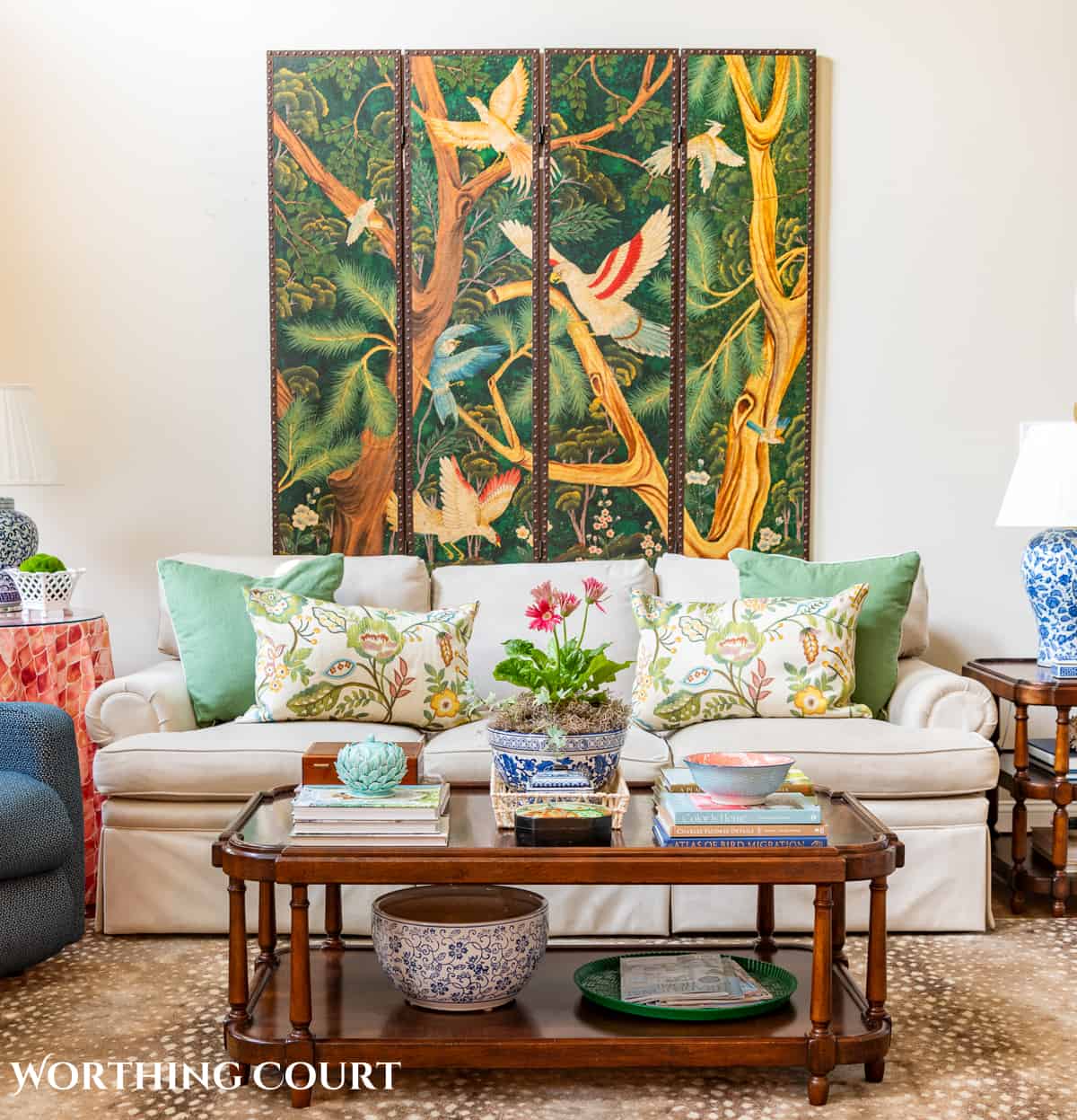 decorative screen on wall above neutral sofa with wood coffee table in front and traditional decorations