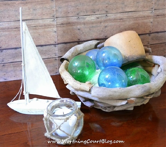 nautical vignette with green and blue glass orbs in a driftwood bowl