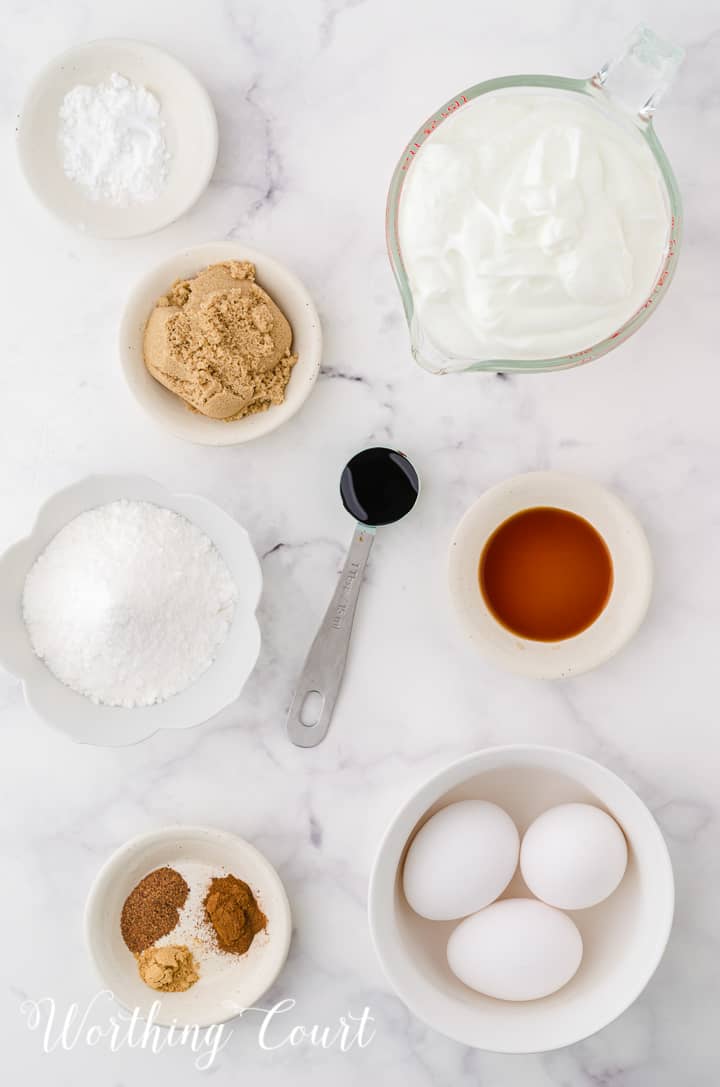overhead view of ingredients to make gingerbread cheesecake on a marble counter