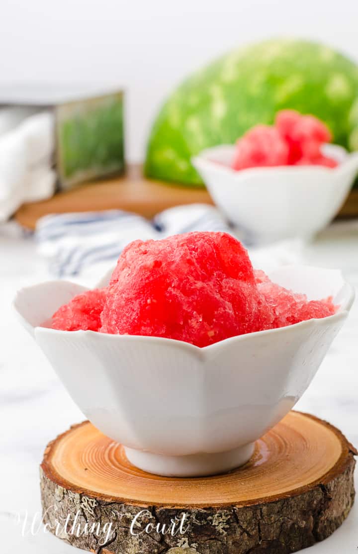 two white bowls filled with watermelon sorbet on top of a wood piece