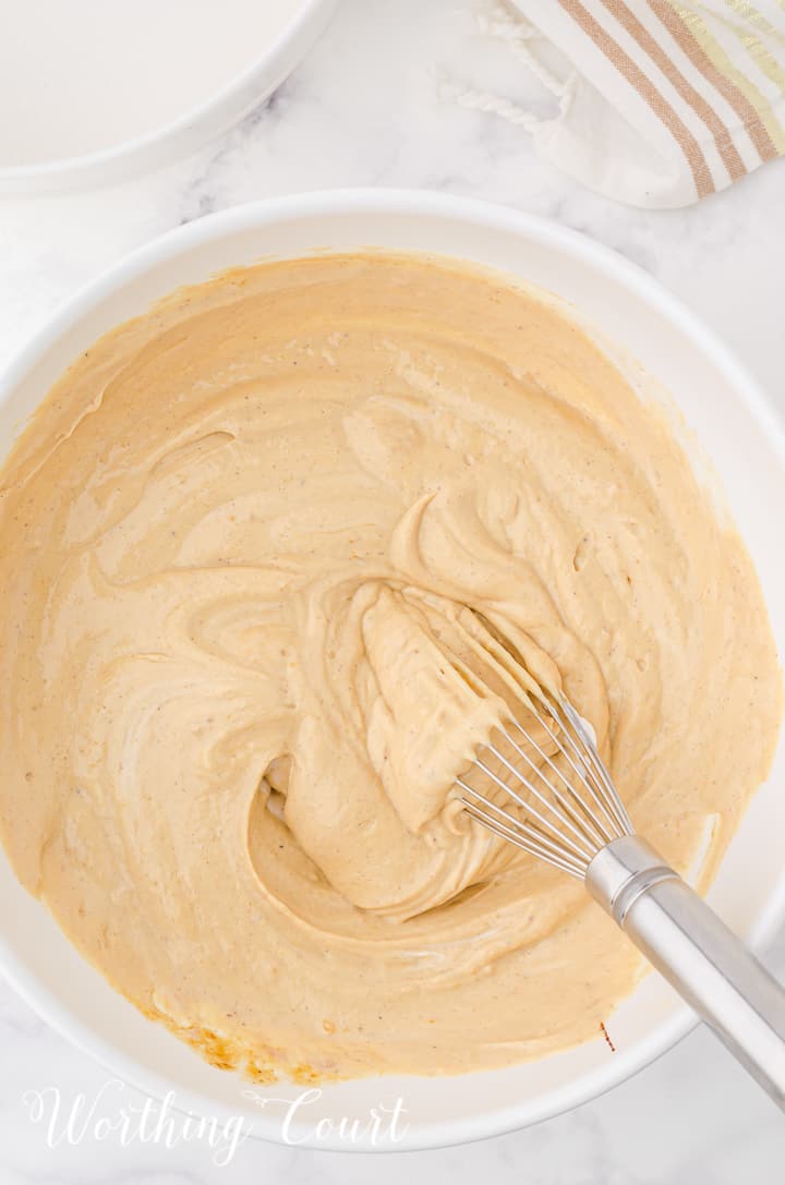 batter for gingerbread cheesecake in a white mixing bowl