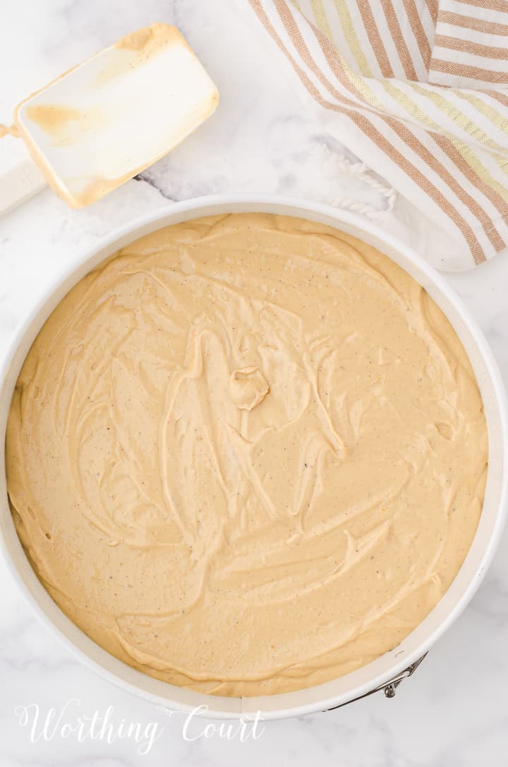 whole gingerbread cheesecake batter poured into white baking dish