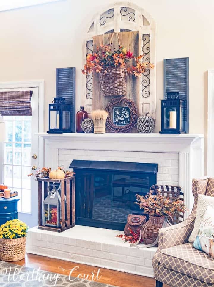 white fireplace overflowing with an abundance of fall decorations