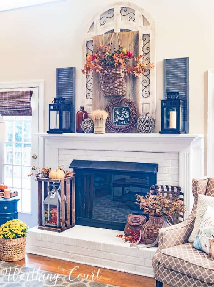 white fireplace overflowing with an abundance of fall decorations