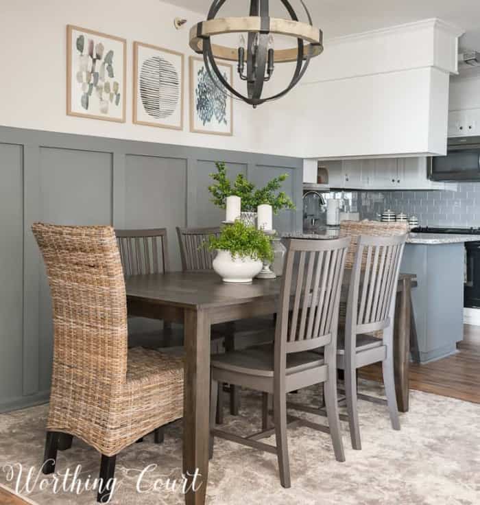 dining room with gray board and batten wall, dining table and six chairs and a modern orb chandelier