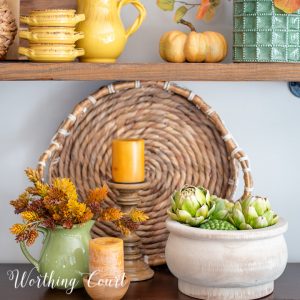 fall vignette on a sideboard with amber, gold and green accessories