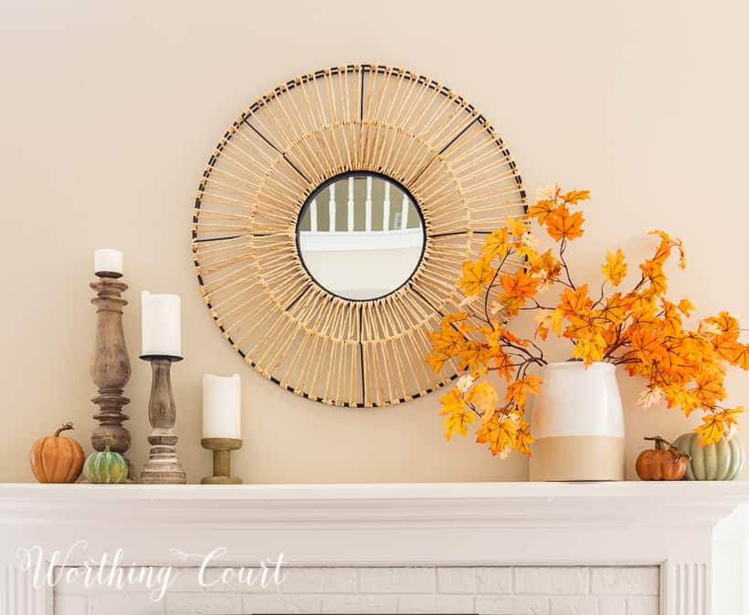 white mantel with round mirror above and fall decorations