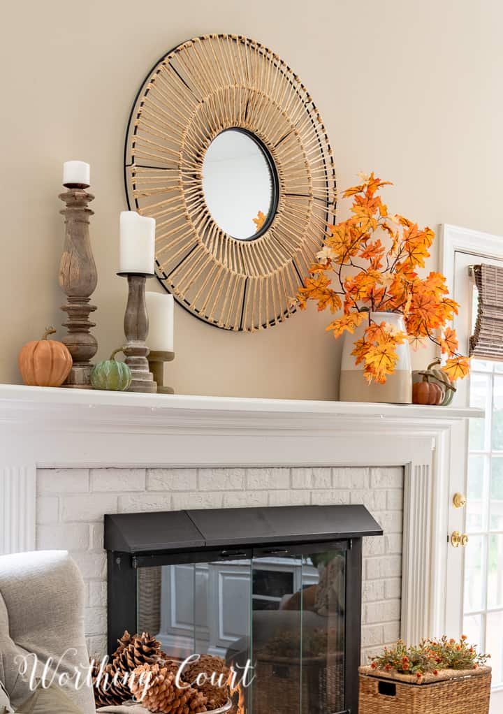 white mantel with round mirror above and fall decorations