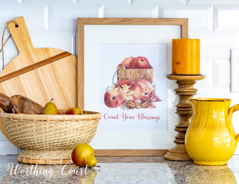 Graphic image of apples in a wood bucket with count your blessings wording below